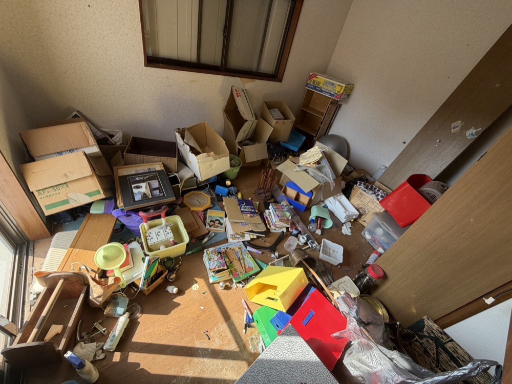 お部屋の片づけ前。段ボールや生活用品が床一面に散乱した状態